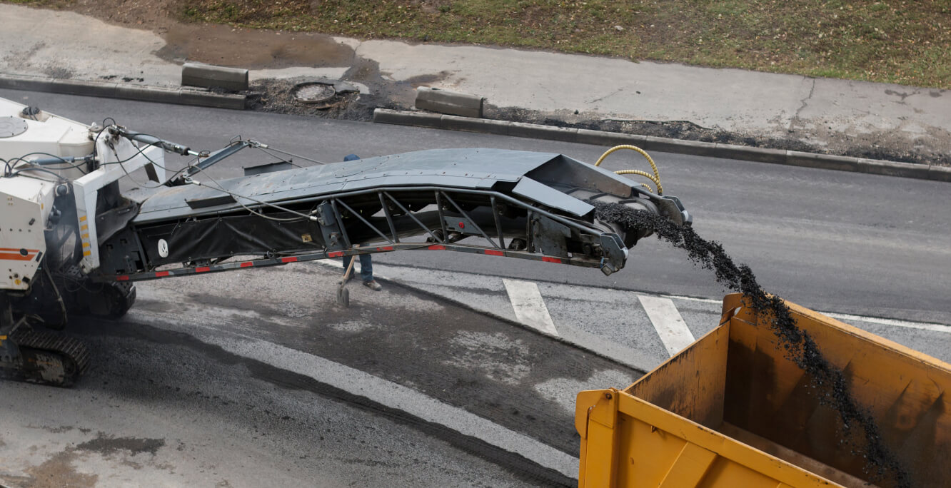 close-up of asphalt milling going in truck bed