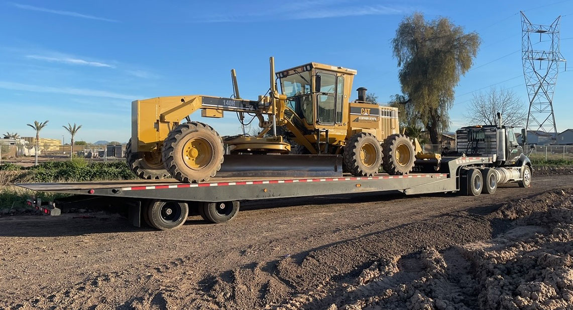 semi truck hauling huge machine on a trailer